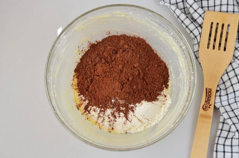 Добавьте какао и муку. На низких оборотах миксера соедините сухие ингредиенты с влажными.