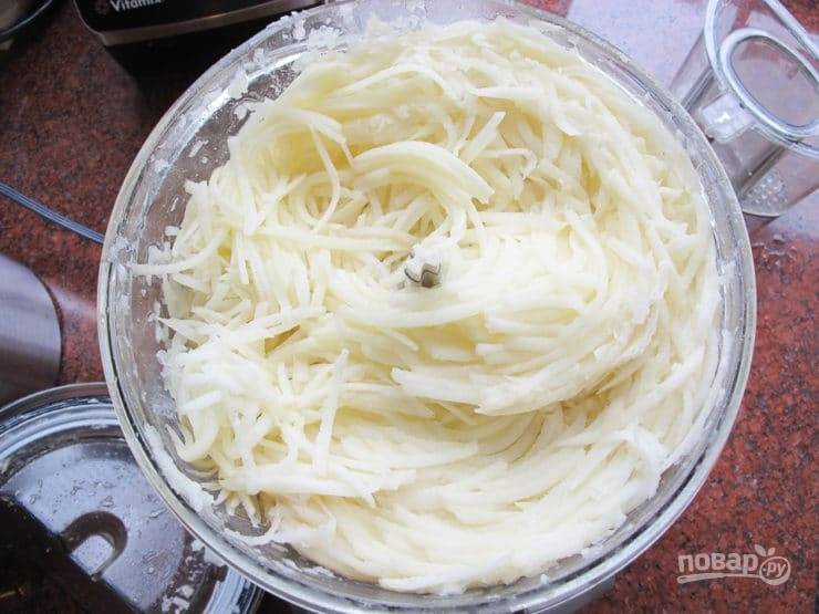 1. Промытый и очищенный картофель натрите на крупной тёрке или измельчите с помощью блендера. Духовку поставьте разогреваться до 200 градусов.