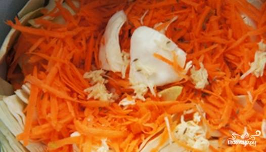 Очищенную морковь натрите на крупной терке, очищенный чеснок выдавите. В большую кастрюлю уложите слоями капусту, морковь, чеснок, перец и тмин.
