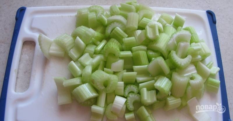 Сначала подготовьте овощи. Нарежьте промытый сельдерей небольшими кусочками.