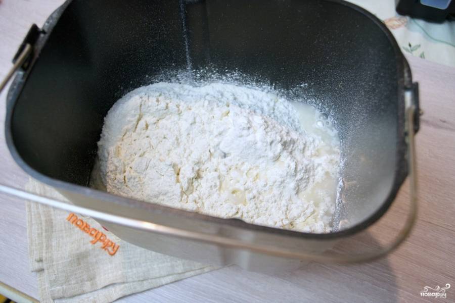 Для приготовления домашнего лаваша в духовке мы используем для замеса хлебопечку. Конечно, замесить тесто можно руками или миксером, но можно это сделать также, как и я. В ведерко поместите просеянную муку. В стакане теплой воды разведите дрожжи, добавьте чайную ложку соли и чайную ложку сахара. Влейте 2 ст. ложки подсолнечного масла и замесите тесто. Я использую для этого режим замеса для теста на пельмени.