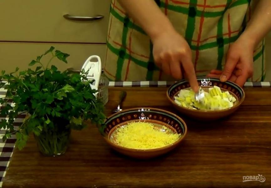 3. Выпекайте основу в разогретой до  200 градусов духовке 10 минут. Приготовьте начинку: нарезанные кубиками яйца разомните вилкой, натрите чеснок, добавьте тертый сыр, майонез и соль. 