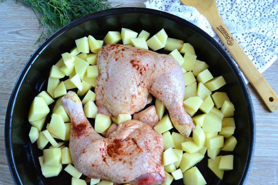 Маринованные куриные окорочка выложите на противень, вокруг разложите порезанный на кусочки картофель. Сверху вылейте остатки маринада, слегка присолите картофель, если нужно.