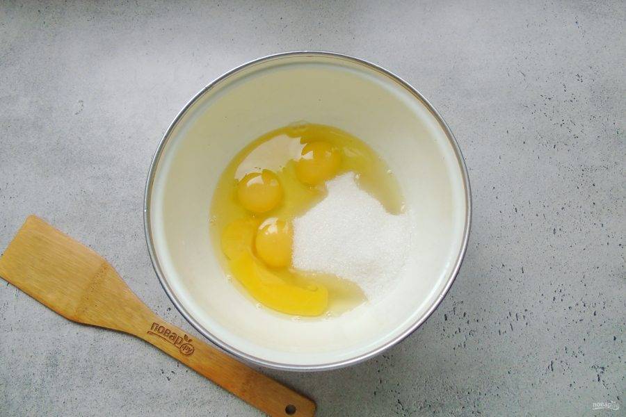 В миску разбейте яйца. Насыпьте сахар и ванильный сахар.