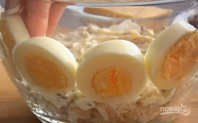 3. Вареные яйца нарежьте колечками и выложите их по краю салата. Остатки яиц еще пригодятся.