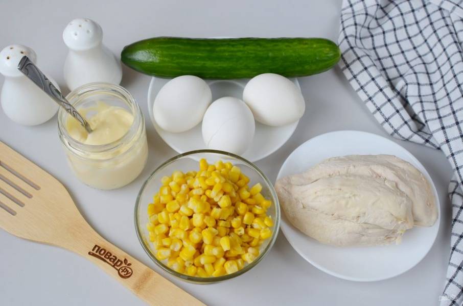 Подготовьте ингредиенты для салата. Отварите в кипящей соленой воде филе до готовности (25-30 минут). Отварите яйца в течение 9 минут, охладите, очистите от скорлупы. С кукурузы слейте воду.