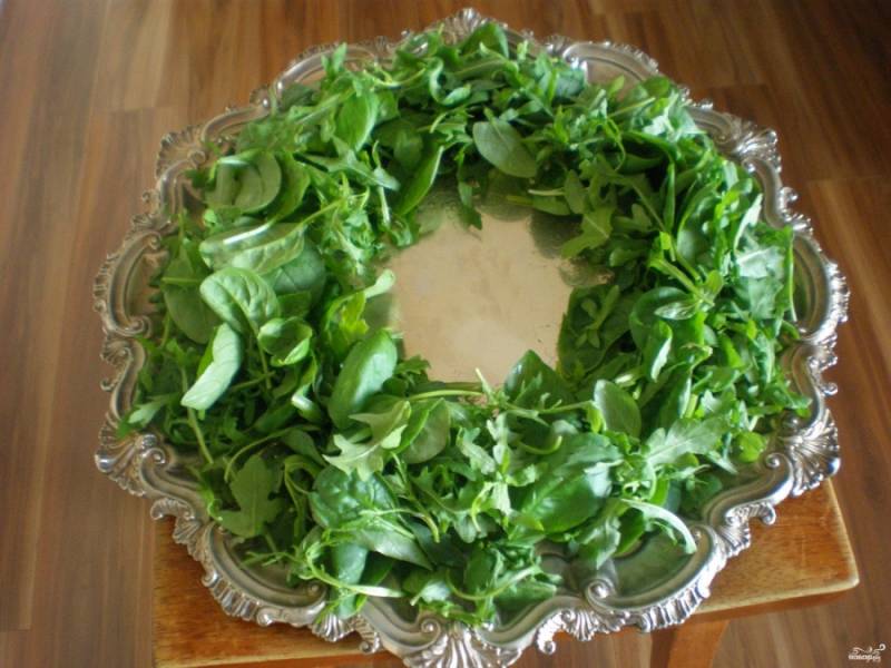 На круглое блюдо выложите красиво зелень в форме венка. Сбрызните оливковым маслом, посолите чуть-чуть.