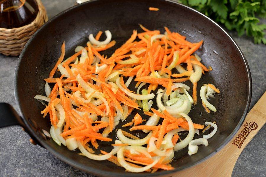Влейте оставшееся масло, выложите в него нарезанный полукольцами лук и натертую морковь. Жарьте овощи минуты 2 на умеренном огне.