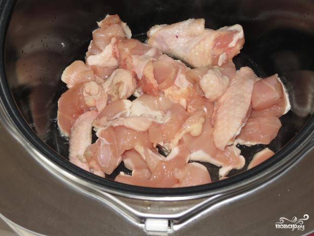 1. Порежьте помытое мясо курицы на мелкие кусочки. Влейте масло в чашу мультиварки, положите кусочки курицы. Немного поджарьте их, используя режим «Жарка».