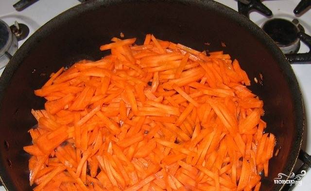 Морковочку поскоблите ножом и хорошенько вымойте под проточной водой. Натрите ее на крупной терке. В сковородку влейте растительное масло без запаха, разогрейте его на плите, выложите в сковородку морковку. 