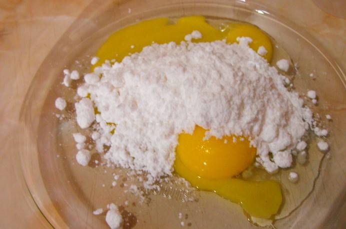 Берем посуду для микроволновке, растираем в ней желток с сахаром и сахарной пудрой.