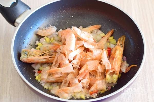 В сковородку к овощам выложите панцыри и головы . Добавьте  воду. Готовьте на среднем огне для получения очень насыщенного рыбного бульона, 15 минут.