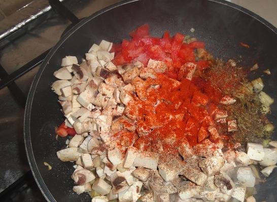Добавляем грибы, кабачок, помидоры и измельченный чеснок. Добавляем соль, специи и тушим минут 10.