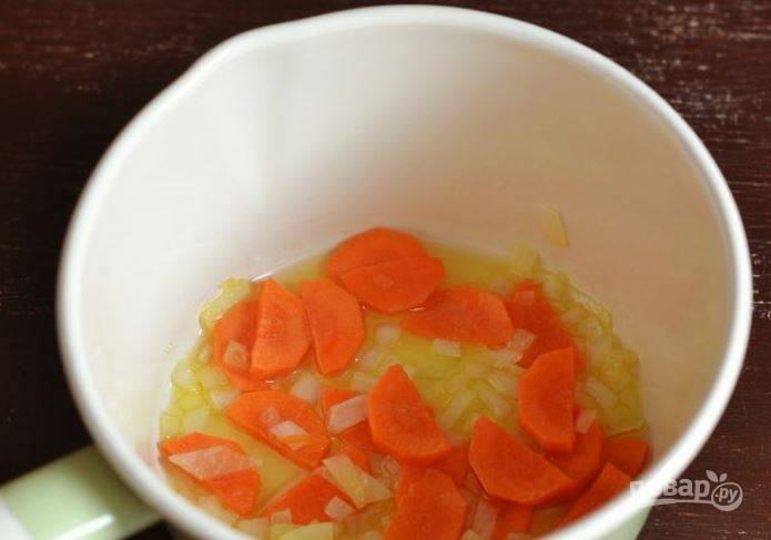 Почистите и вымойте морковь и лук. Порежьте лучок небольшими кубиками или полукольцами, а морковь — кружочками или более мелко. В сотейнике разогрейте растительное масло и пассеруйте овощи на нем в течение пяти минут. 