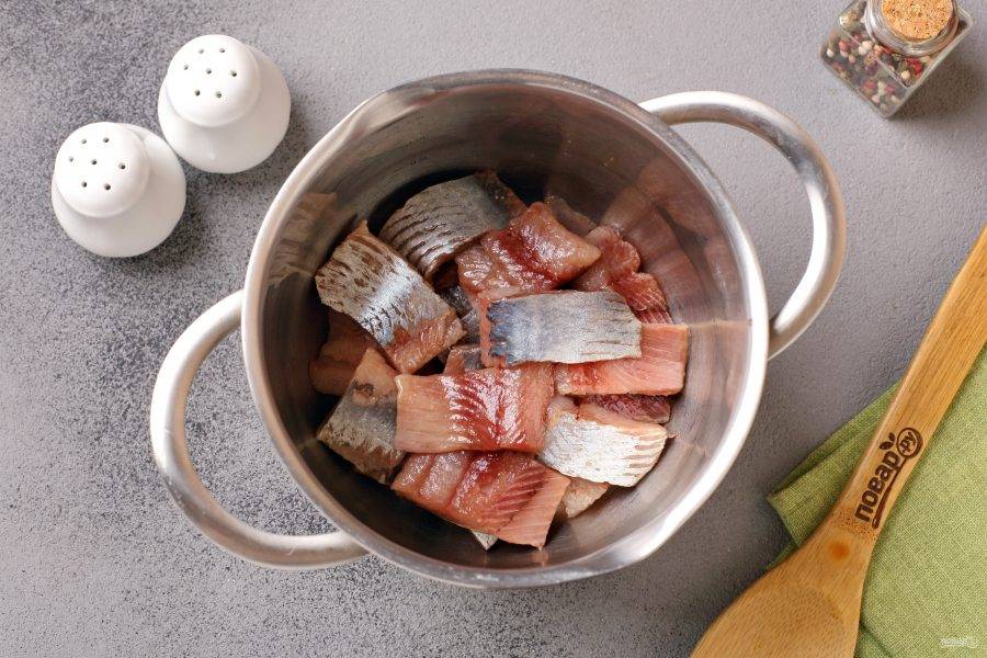Селёдку разделайте на филе, нарежьте порционными кусочками и переложите в любую глубокую ёмкость.