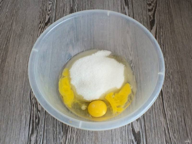 В чашу разбейте яйца, добавьте сахар.
