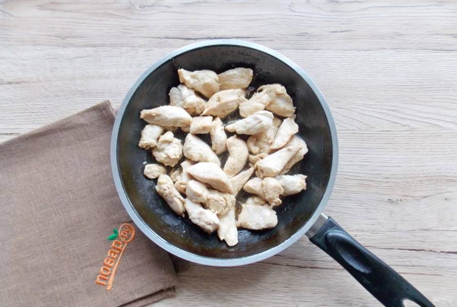 Куриное филе помойте и нарежьте небольшими кусочками. Выложите в сковороду с маслом. Обжарьте на среднем огне до мягкости в течение 10-12 минут. Налейте соевый соус и перемешайте.