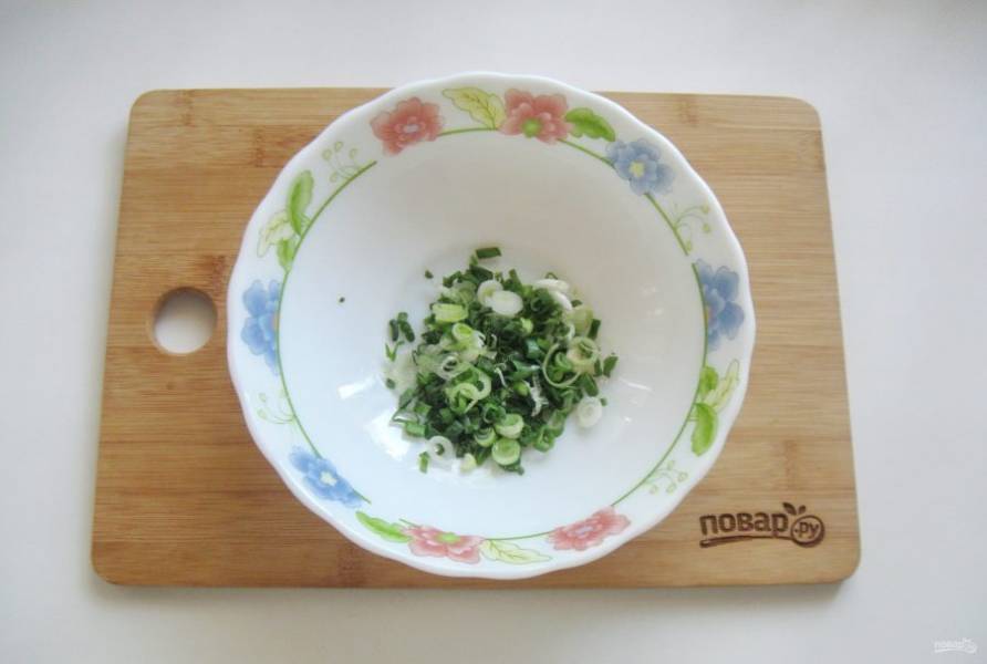 Зеленый лук помойте и мелко нарежьте. Выложите в салатник.