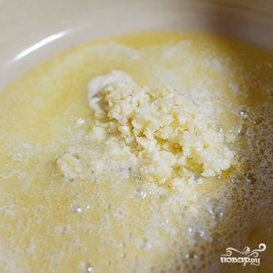 В сковороде растапливаем сливочное масло, бросаем в него измельченный чеснок.
