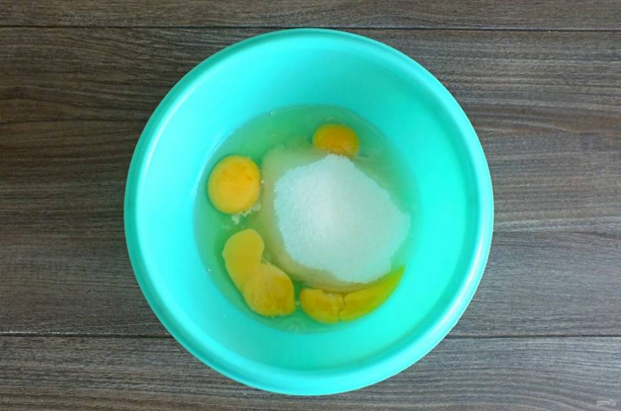 В чаше соедините яйца и сахар. Взбейте в пышную, белую массу.