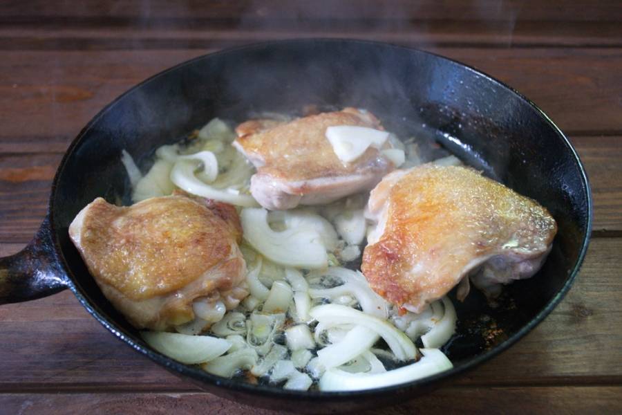 Когда курица обжарится, добавьте лук. Тушите все вместе 5 минут.
