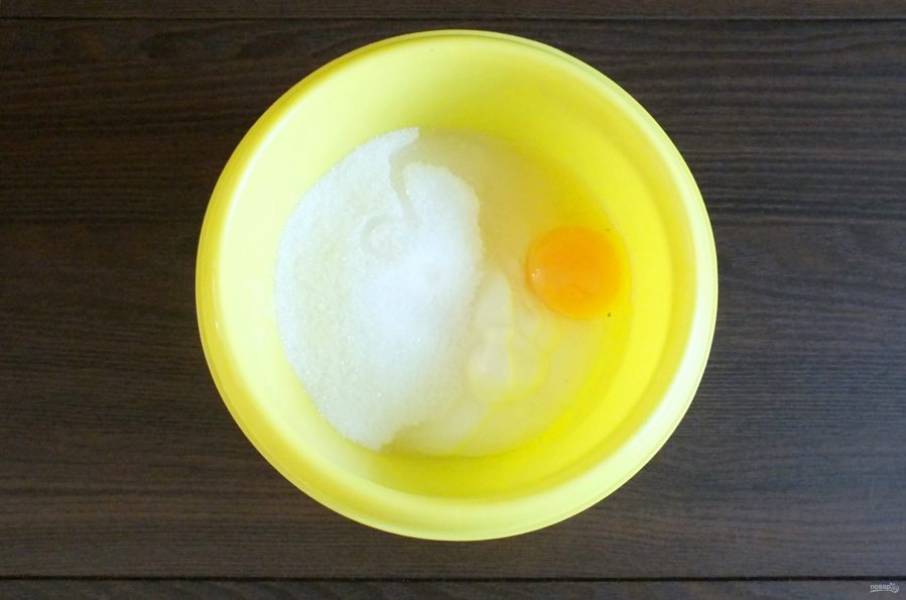 Сделайте заливку. В чашу выложите сметану, добавьте яйцо, 150 грамм сахара. Перемешайте.