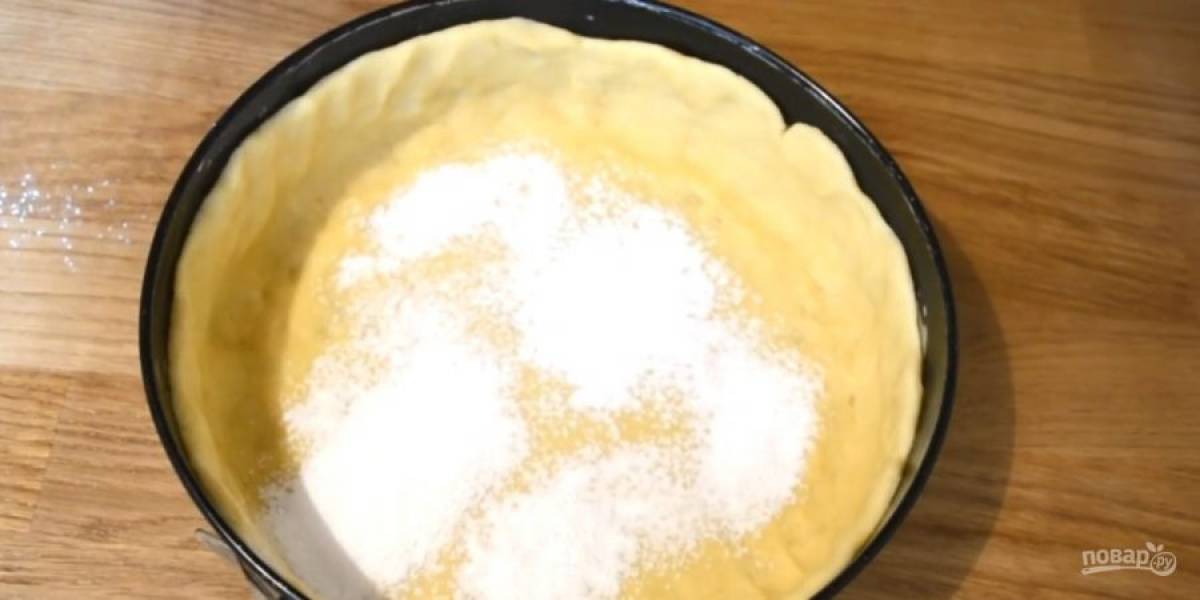 4. Оставшееся тесто раскатайте в пласт толщиной 3-5 мм. Форму для выпечки смажьте сливочным маслом и присыпьте манкой. Выложите тесто в форму и сформируйте бортики.