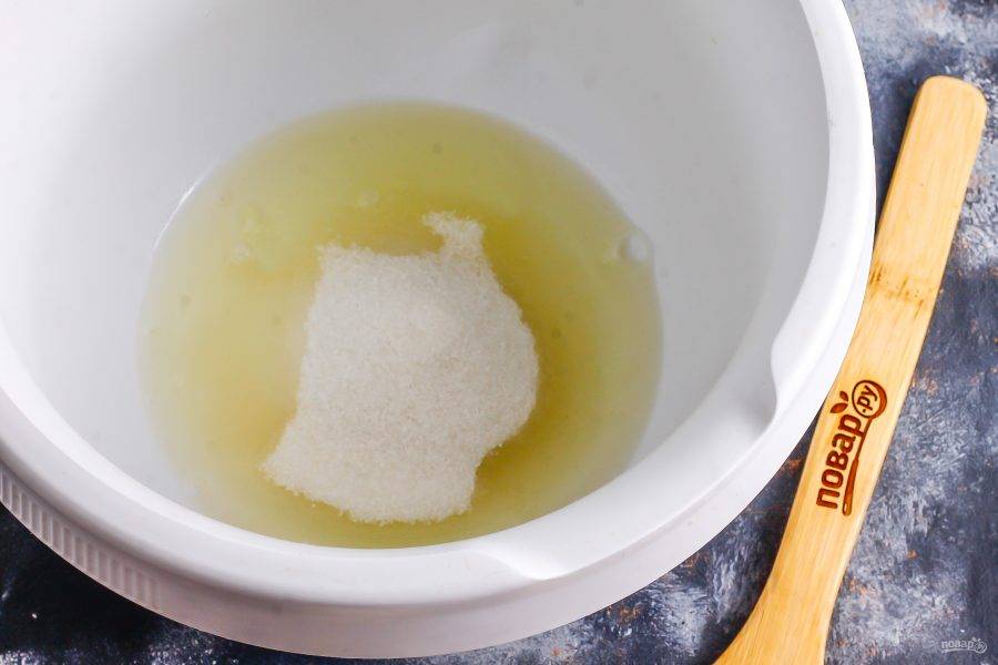 Отделите белки от желтков и влейте их в чашу кухонного комбайна, всыпьте туда же щепотку соли и сахар.