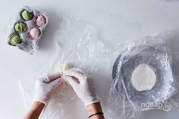 3. Работать нужно быстро, желательно в перчатках и используя пленку, чтобы мороженое не таяло. Быстро сверните тесто и сформируйте аккуратный шарик. 