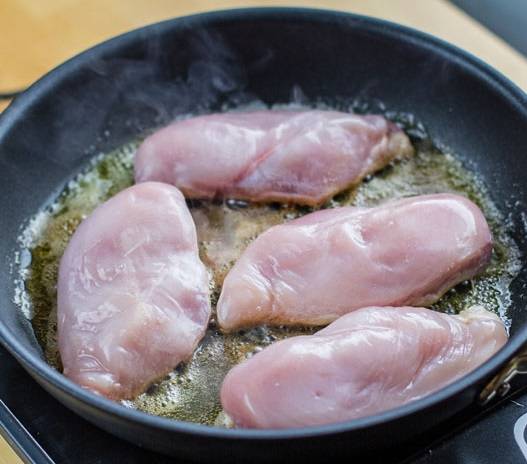 2. Куриные грудки вымыть, просушить немного и отправить на сковороду. Кстати, этот рецепт приготовления тушеной курицы в сметанном соусе подойдет не только для филе, но и для разделанной на части птицы. 