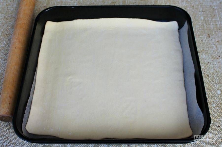 Дрожжевое тесто раскатываем на бумаге для выпечки, толщиной 2 мм.