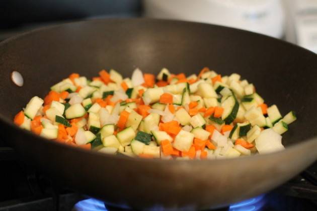 1. Для начала необходимо подготовить овощи. Морковь и луковицу нужно очистить и нарезать кубиками. Также измельчить цуккини и грибы. Это классический рецепт омлета с рисом по-корейски, в который можно внести некоторые коррективы, исходя из наличия ингредиентов. Прекрасно подойдет сюда также сладкий перец, например. На сковороде (идеальный вариантом для этого блюда будет вок) разогреть немного растительного масла и отправить туда овощи. Обжарить до мягкости, периодически помешивая. 