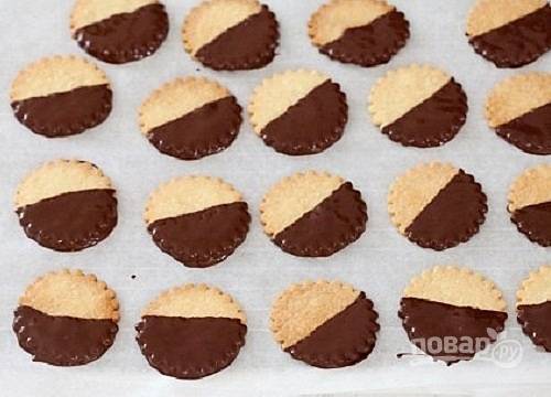 Макаем остывшее печенье в шоколад. Пока шоколад не застыл, можно сверху посыпать печенье разноцветной кондитерской посыпкой. Выкладываем печенья на пергамент или решетку до застывания шоколада.