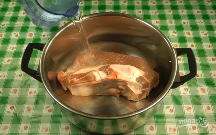 Мясо промойте. Залейте его в кастрюле 3-4 литрами воды. Поставьте вариться бульон. Не забывайте убирать пену. Через 30 минут всыпьте перловку. Добавьте лавровый лист.