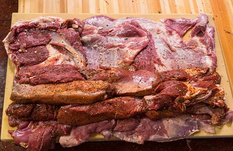 Разложите плоские куски баранины, на них выложите маринованное мясо. 