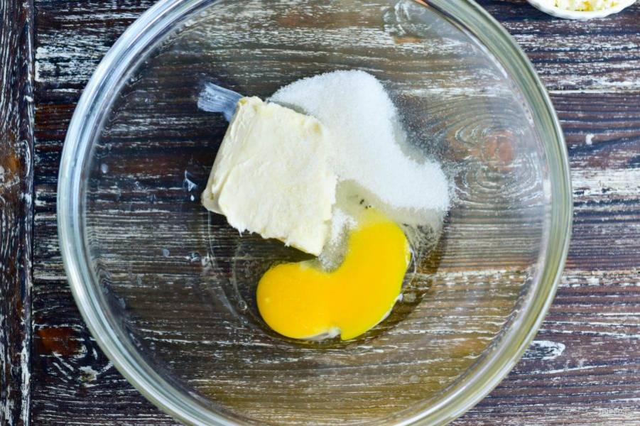 В миску вбейте яйцо, добавьте сахар (60 грамм) и сливочное масло.