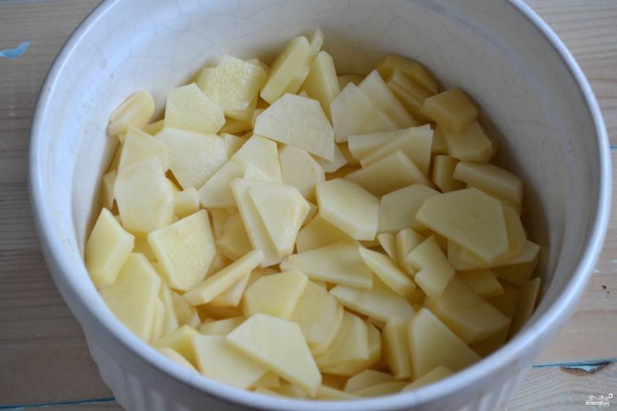 Выложите картофель в керамическую форму для запекания.