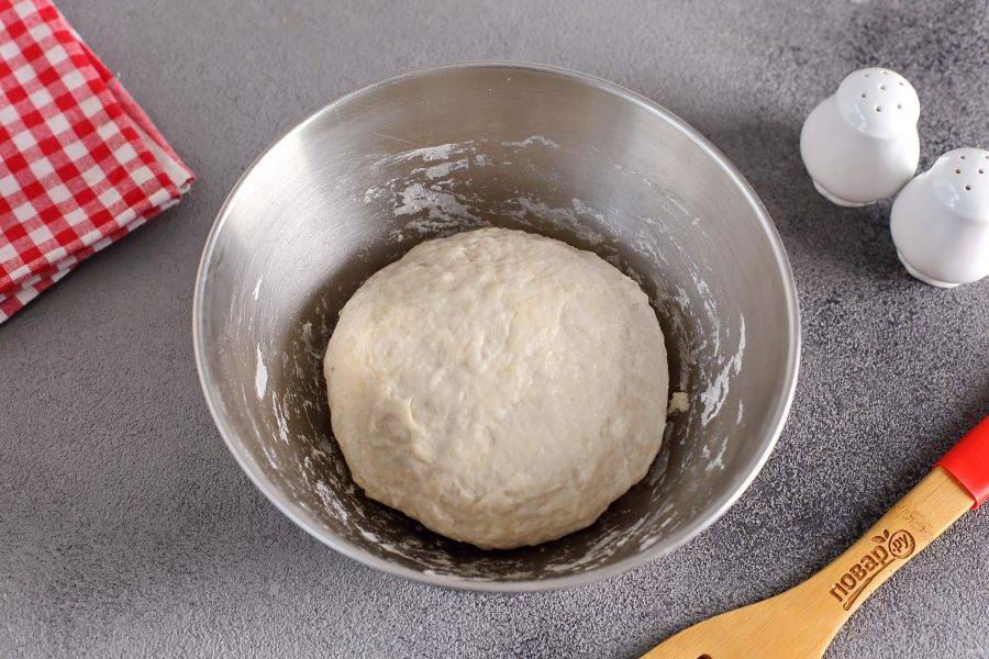 Замесите мягкое и чуть липкое тесто. Соберите его в шар, смажьте маслом, накройте пленкой и оставьте в теплом месте на 1 час. Тесто должно увеличиться в размере.