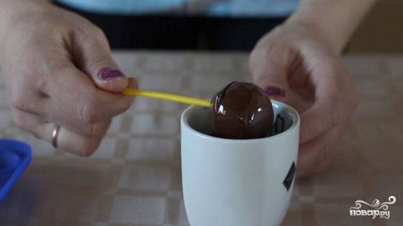 8. Теперь окунаем каждый попкейк в шоколад и хорошо проворачиваем трубочку, чтобы глазурь равномерно распределилась по всей поверхности.