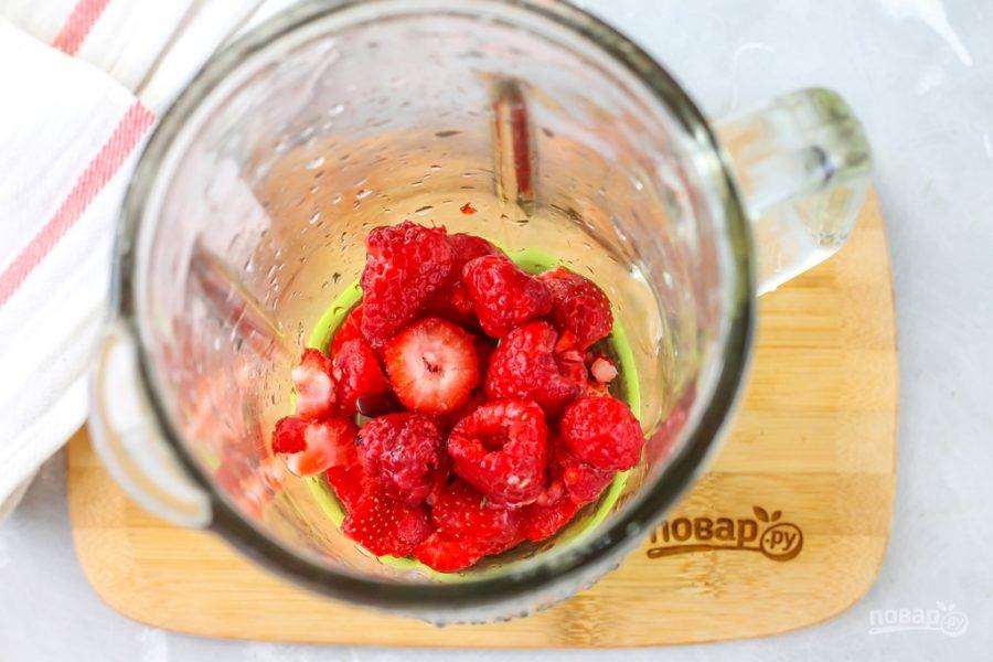 Клубнику и малину промойте в воде, удалите с ягод хвостики, клубнику нарежьте слайсами и высыпьте ягоды в чашу блендера. Лучше использовать кувшинный блендер, а не погружной, чтобы не перебить мелкие ягодные косточки. При добавлении замороженных ягод, разморозьте их заранее при комнатной температуре в течение 15 минут.