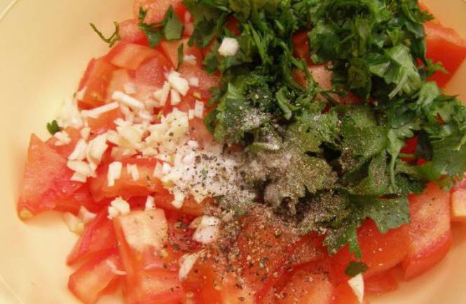 Соединяем в салатнице: помидоры, кинзу и чеснок. Добавляем перец и соль по вкусу. Вливаем растительное масло.