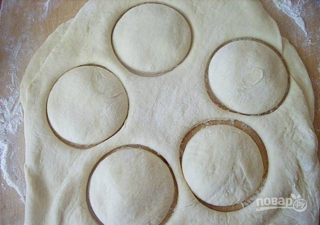 Закройте тесто вторым пластом. Вырежьте пончики круглой формы стаканом или кружкой.