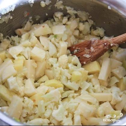 Когда лук станет мягким - добавляем в кастрюлю картофель и капусту, перемешиваем и готовим 1 минуту.