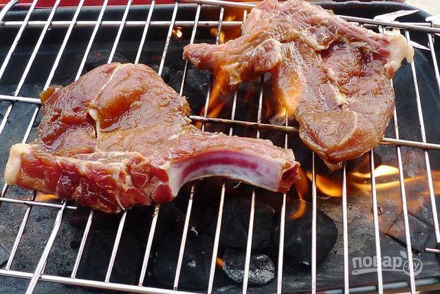Когда мясо промаринуется, разожгите мангал, выложите мясо на решетку и начните жарить.