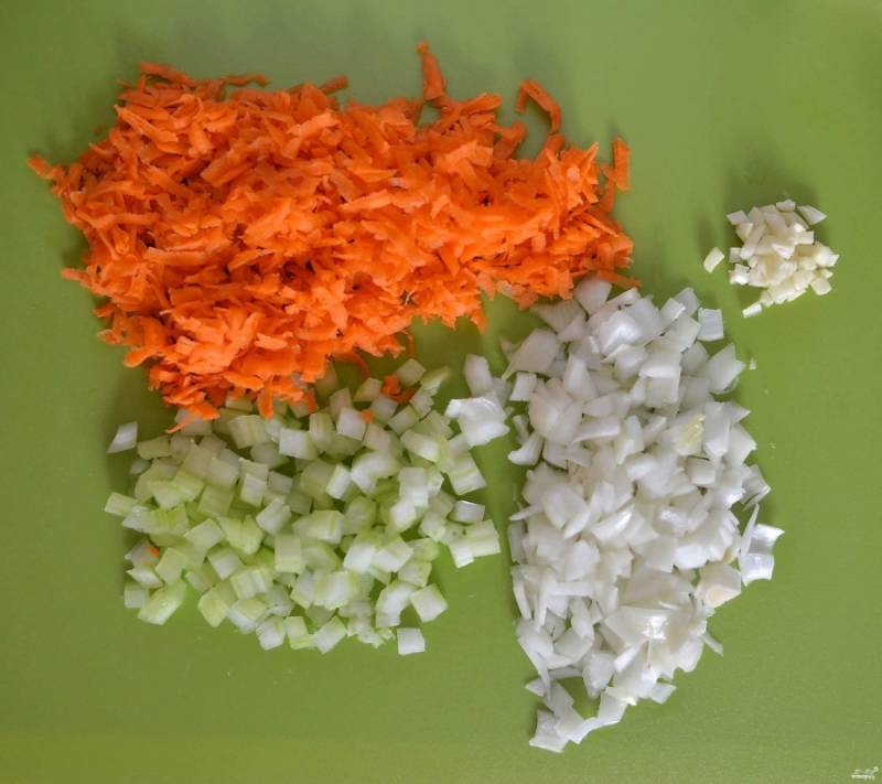 Овощи помойте и почистите: морковку натрите на крупной терке, сельдерей и лук порежьте небольшими кубиками, чеснок мелко порежьте. 