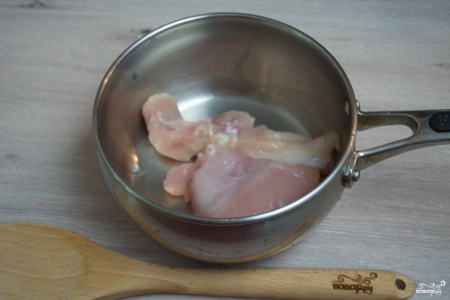 Для приготовления куриного супа с лапшой нам необходимо взять куриное мясо. Я беру грудку, но можно взять и окорочок. Поместите мясо в кастрюльку. Залейте кипятком и поставьте вариться. Нужно сделать небольшой огонь (ниже среднего). Варите мясо медленно, чтобы бульон не кипел, а едва варился. Это позволит сделать идеальный прозрачный бульон.