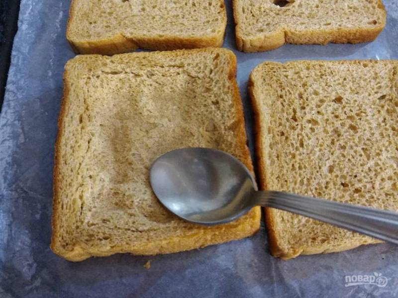2. Примните центр тоста с помощью столовой ложки. Смажьте хлеб растопленным маслом.