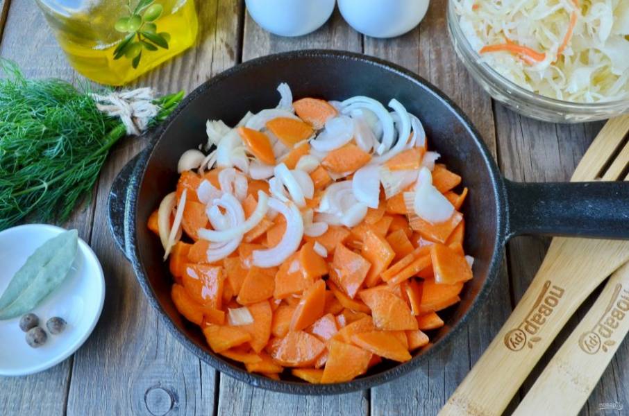 Очистите лук и морковь, порежьте некрупно и обжарьте на двух столовых ложках масла до готовности.