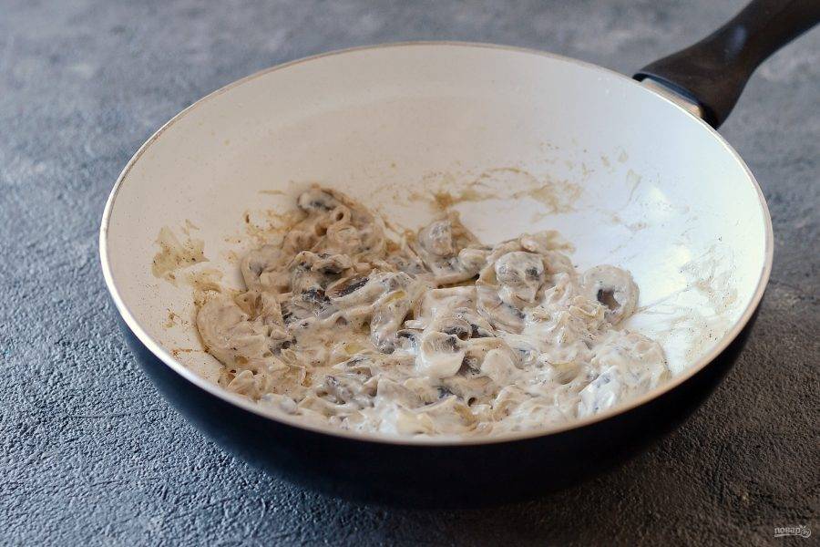 Репчатый лук полукольцами, шампиньоны пластинами. Обжарьте лук и грибы на сковороде до испарения влаги. Посолите и перчите по вкусу. В конце добавьте сметану, перемешайте.