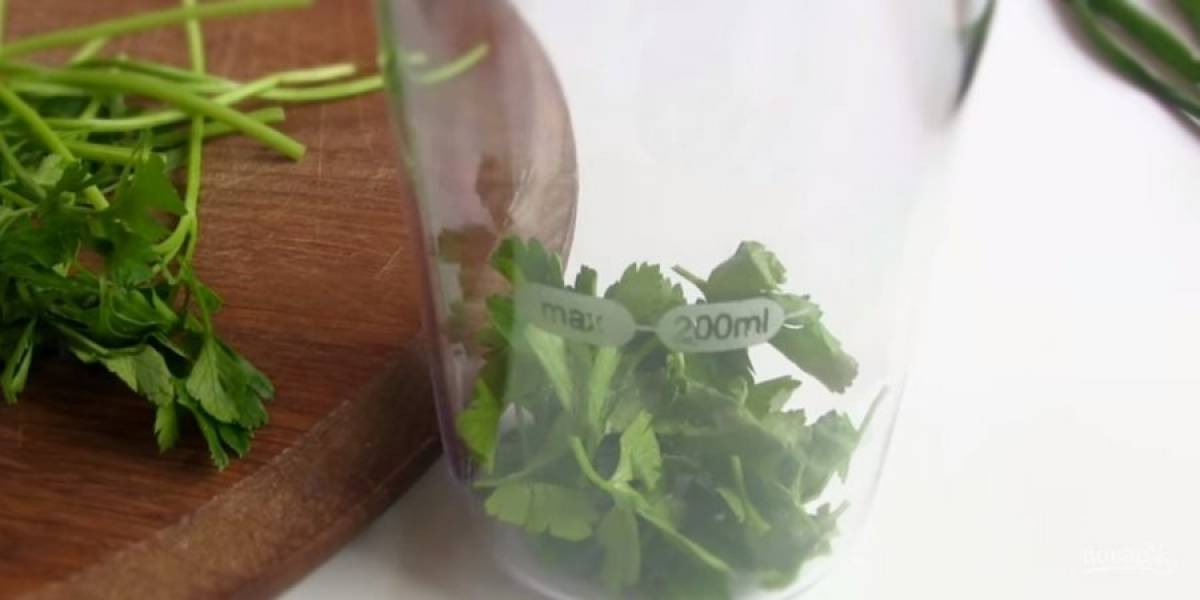 1. Отделите листья петрушки от веточек и отправьте их в чашу блендера. Слегка измельчите зеленый лук, крупно нарежьте маринованные огурцы (корнишоны) и добавьте в чашу блендера.
